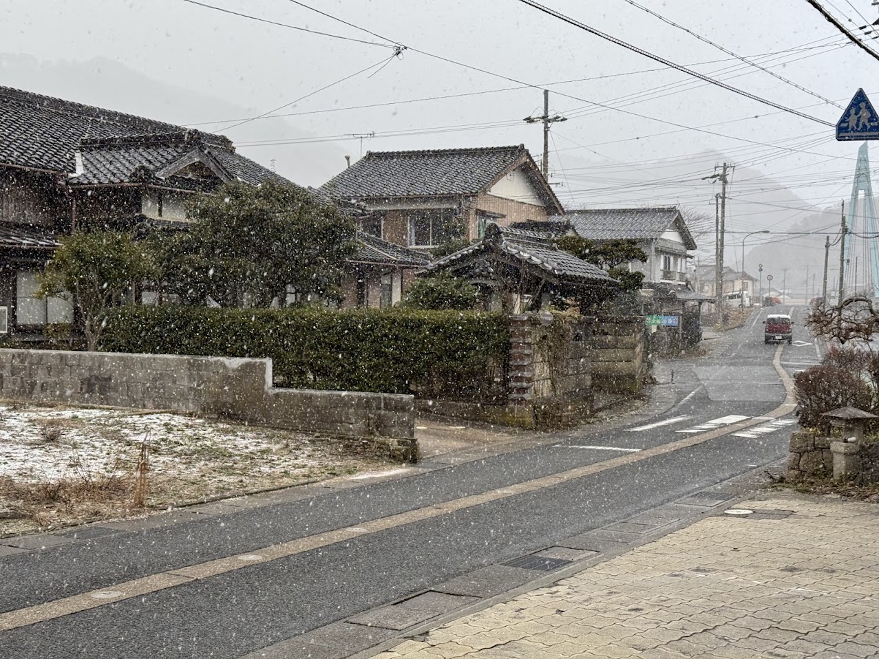 民宿かどや前、強い北風の中降る雪