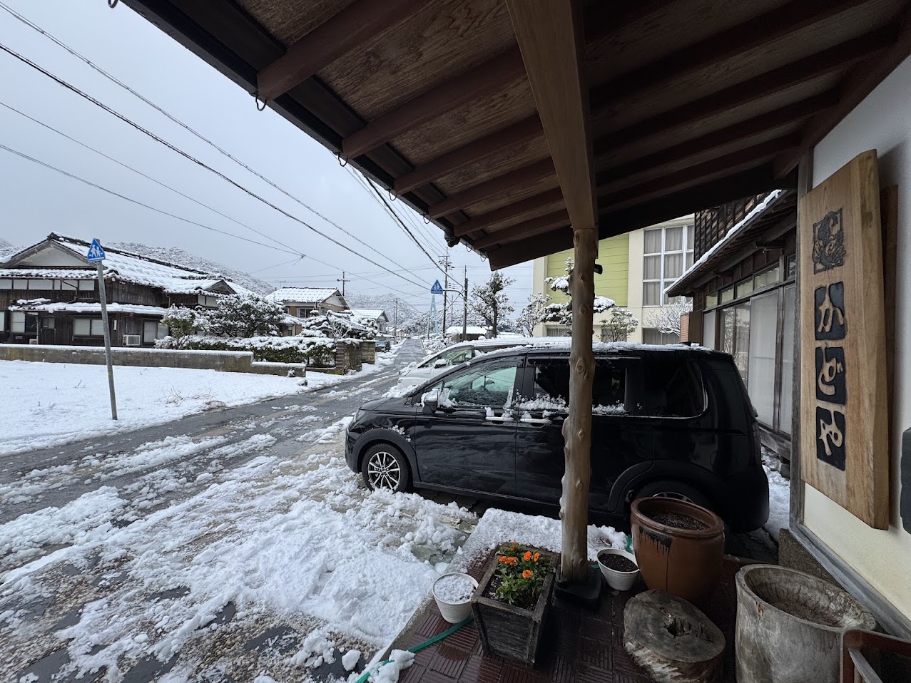 民宿かどや前、南風の中積もる雪